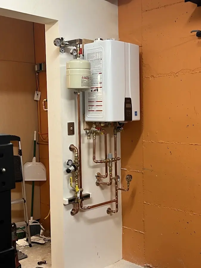 Plumbing technician inspecting water heater connections in Sheffield